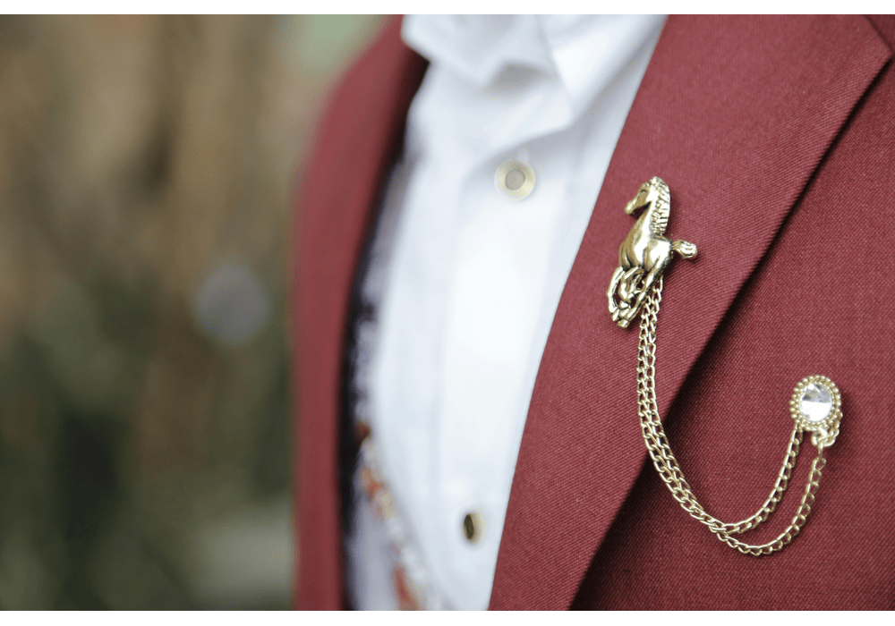men wearing burgundy suit with a chain brooch