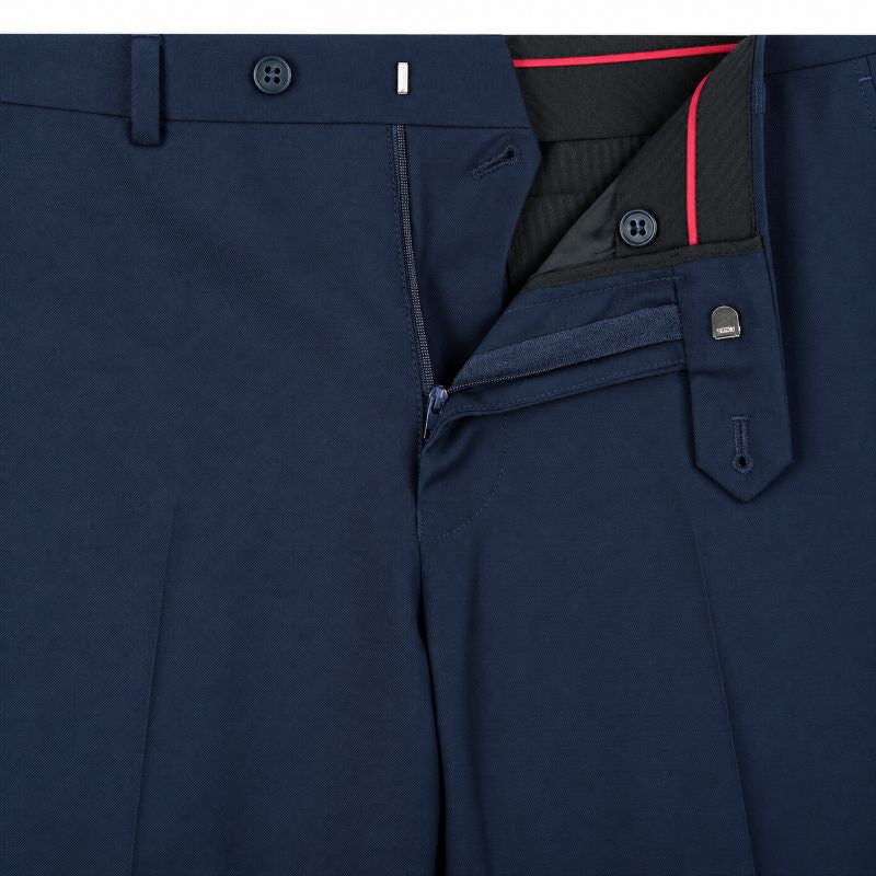 Close-up of navy blue trousers showing the waistband, front zipper, flap pocket, and interior lining with a thin red accent.