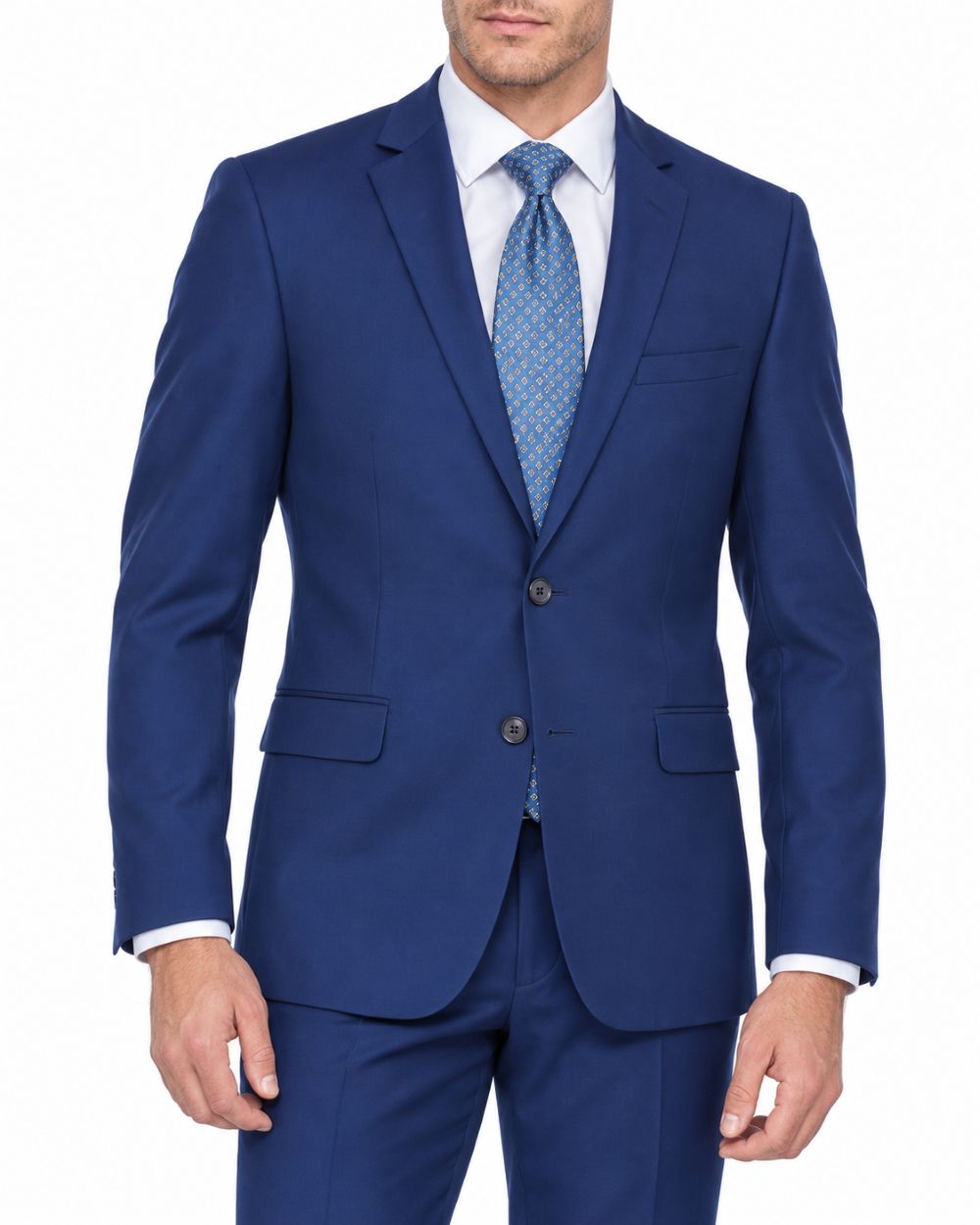 A man wearing a blue two-piece suit with a white dress shirt and a blue patterned tie, shown from the waist up against a plain white background.