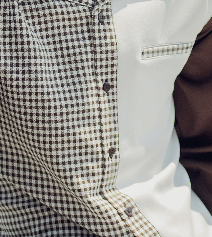 Close-up of the luxurious brown checkered fabric and exquisite button on a MONTIQUE men's long-sleeve walking suit.