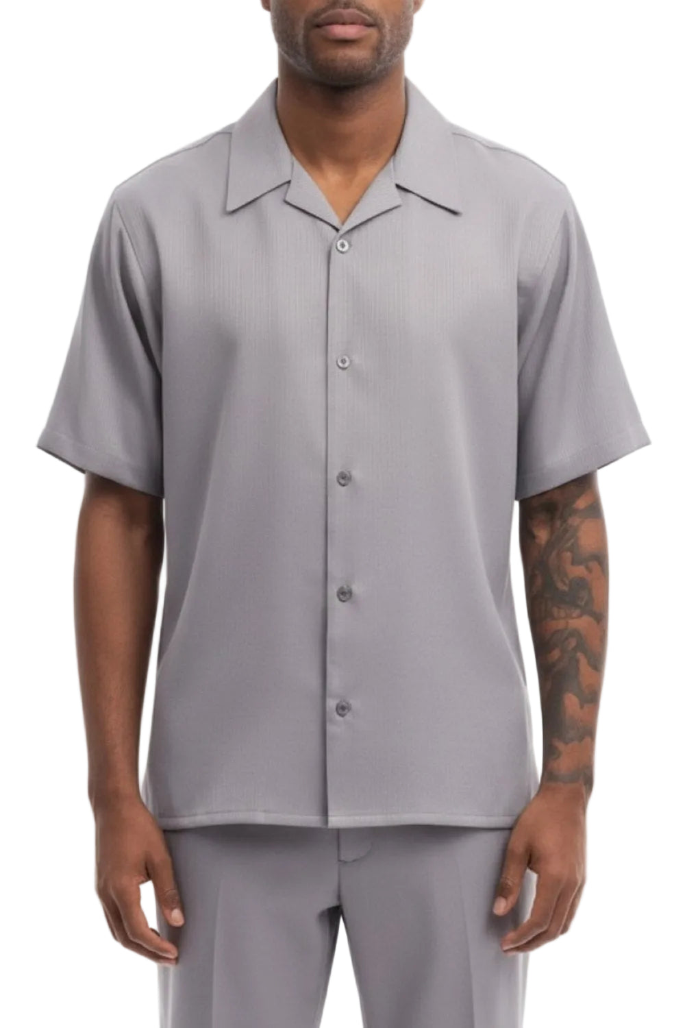 Man wearing a gray short-sleeve button-up shirt and pants on a white background