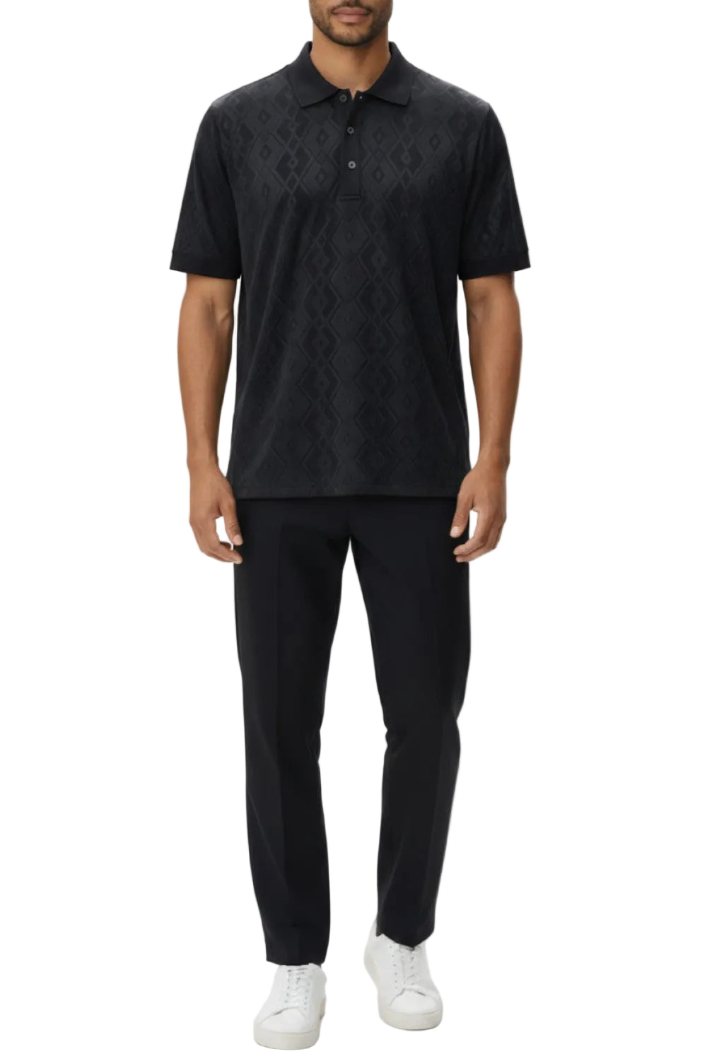 Person wearing a black patterned polo shirt and pants with white shoes on a white background