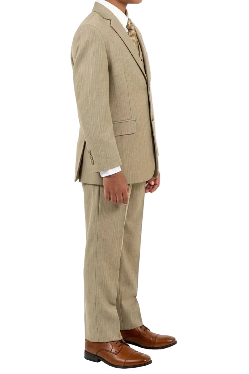 A boy wearing a five-piece beige-colored suit with a matching vest and trousers, a light dress shirt, a cream tie, and brown leather dress shoes, shown against a plain white background.