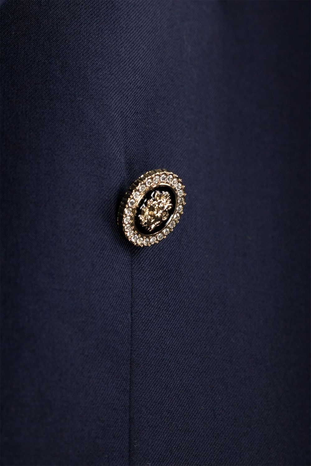 Close-up of a decorative button on a navy blue fabric background