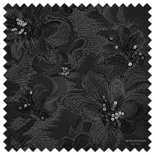 Black floral lace fabric swatch with embroidered flowers and sequined details, shown with zigzag-cut edges and a small 'Suits Outlets New York' mark in the lower right corner.