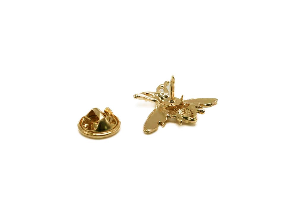 Gold airplane-shaped lapel pin on a white background