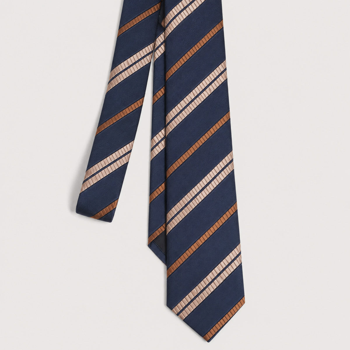 A navy blue necktie with diagonal stripes in textured tan, brown, and cream, displayed against a light gray background.