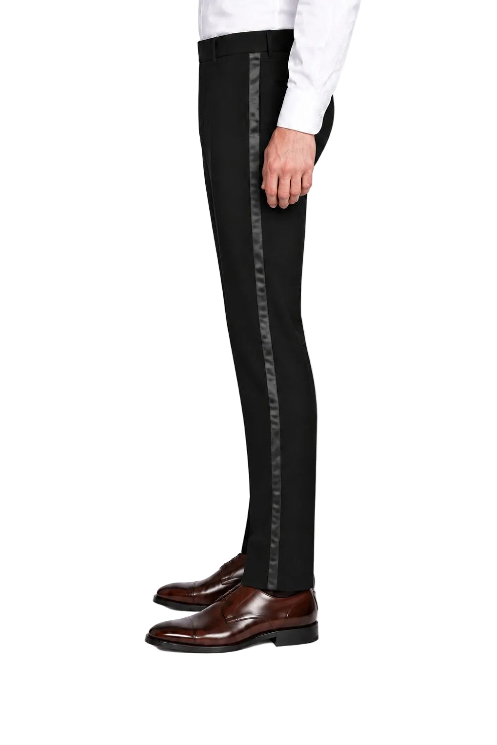 A side-profile view of a person wearing slim black trousers with a vertical metallic silver stripe down the side, paired with a white shirt and brown dress shoes, on a white studio background.