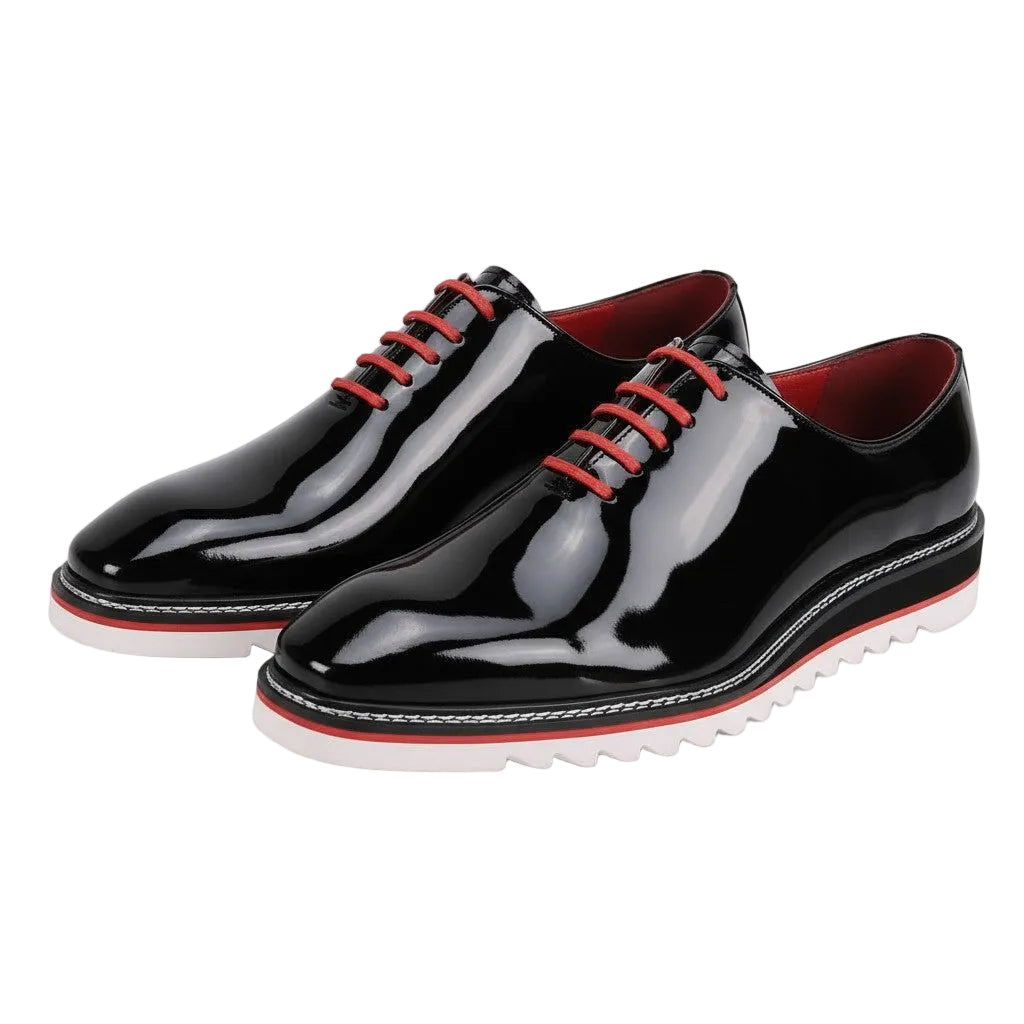 Black patent leather shoes with red laces on a white background
