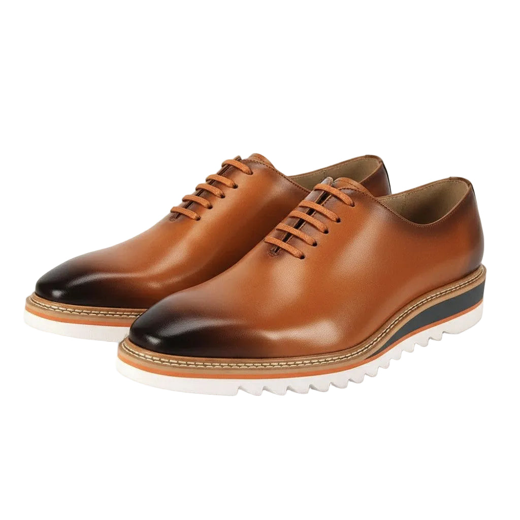 Tan leather shoes with black toes on a white background