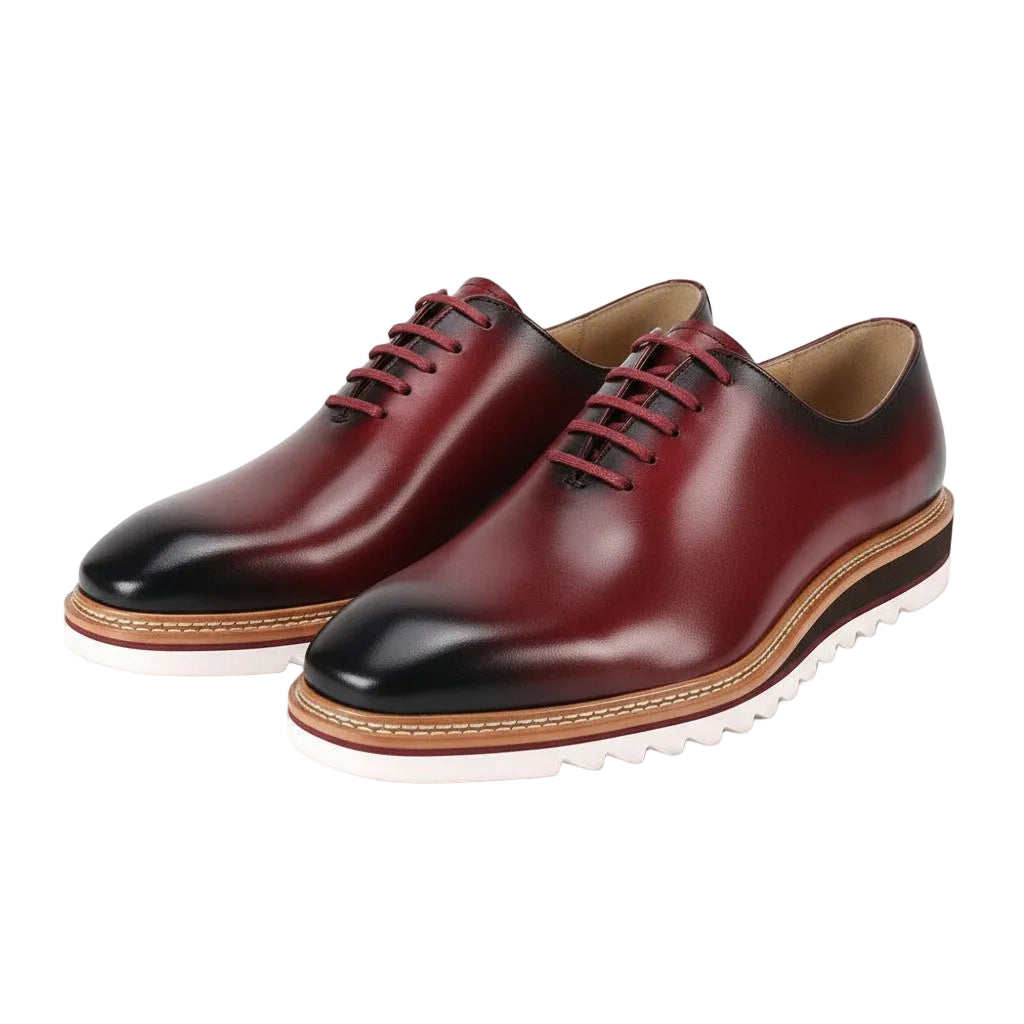Pair of Wine leather shoes with black toes on a white background