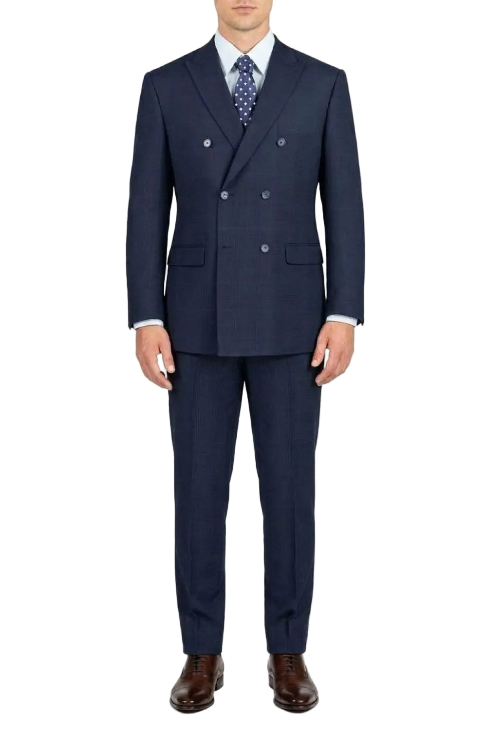 A man wearing a navy blue double-breasted suit with a subtle windowpane pattern, paired with a white dress shirt, a blue patterned tie, and brown leather dress shoes, photographed against a solid white background.