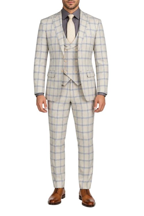 A man wearing a light beige and blue windowpane plaid three-piece suit, including a jacket, vest, and trousers, styled with a grey shirt, cream tie, and brown leather dress shoes against a plain white background.