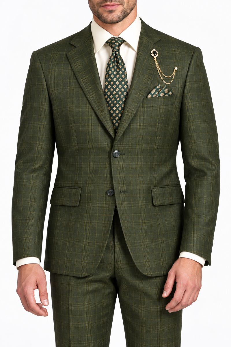 A man wearing an olive green plaid three-piece suit with a white dress shirt, a patterned green tie, and a pocket square, shown from the waist up against a white background.