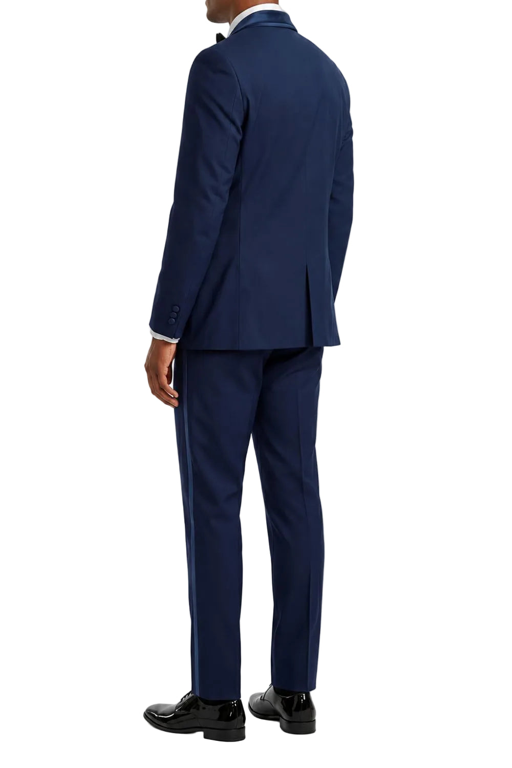 A man wearing a navy blue suit, shown from the back, paired with a white dress shirt, black bow tie, and black dress shoes, against a plain white background.