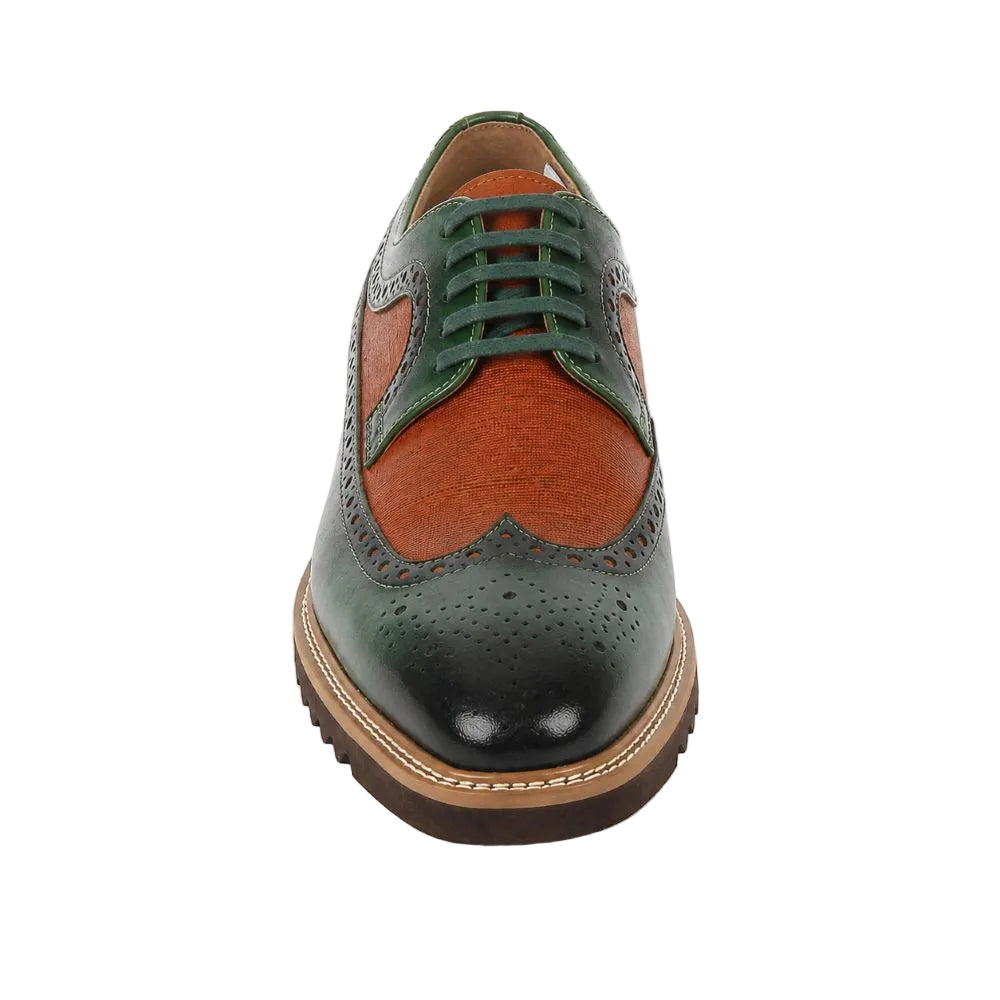 A men's wingtip oxford shoe featuring a color-blocked design with a dark green brogue toe and heel, a textured orange-brown vachetta leather vamp, and matching green laces, set against a plain white background.