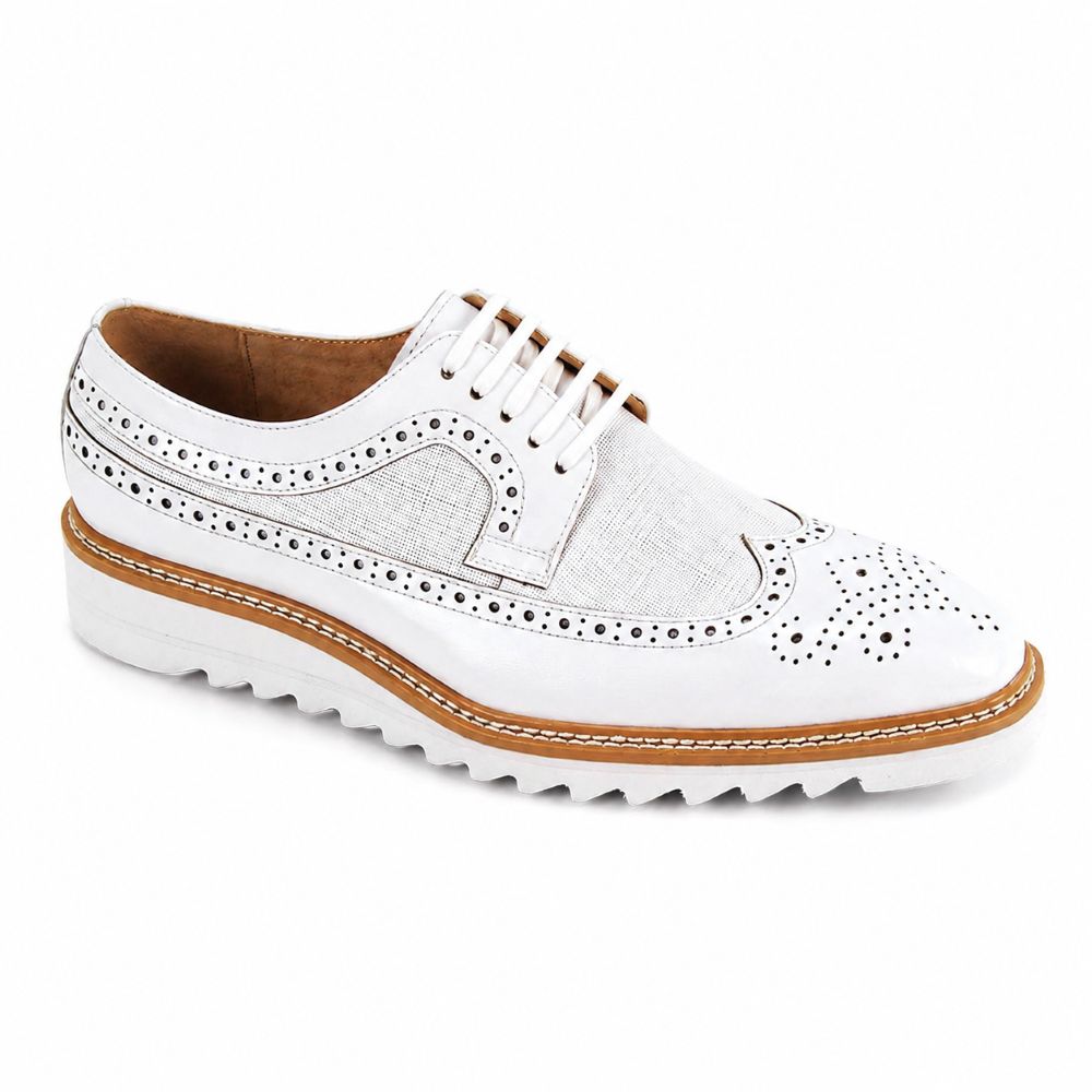 A white leather wingtip oxford shoe with decorative perforations, white laces, a tan midsole, and a white wavy rubber sole, shown on a plain white background.