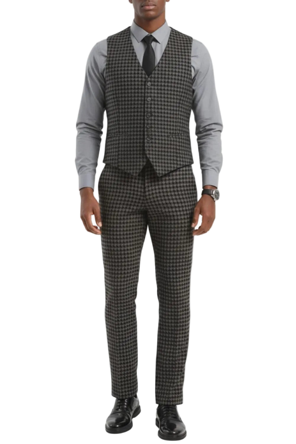 Man wearing a gray houndstooth vest with a white shirt and black shoes on a white background