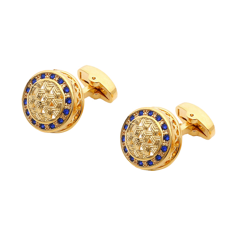 Gold cufflinks with blue gemstones on a white box