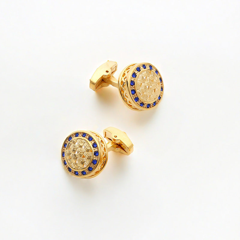 Gold cufflinks with blue gemstones on a white background