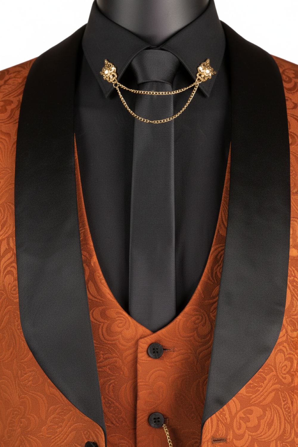 Orange paisley vest with black lapels and a black tie on a white background