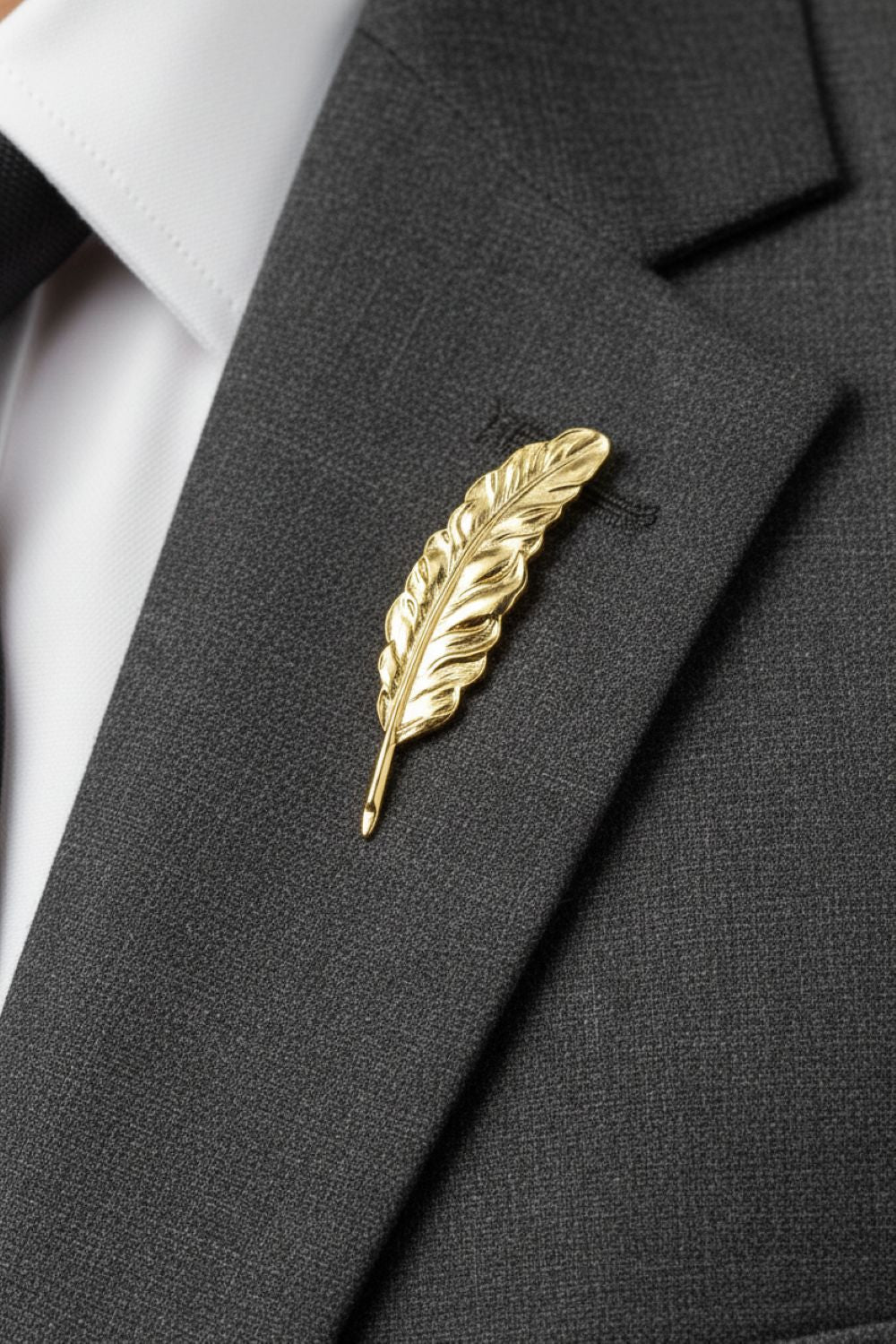 Gold feather lapel pin on a black suit jacket