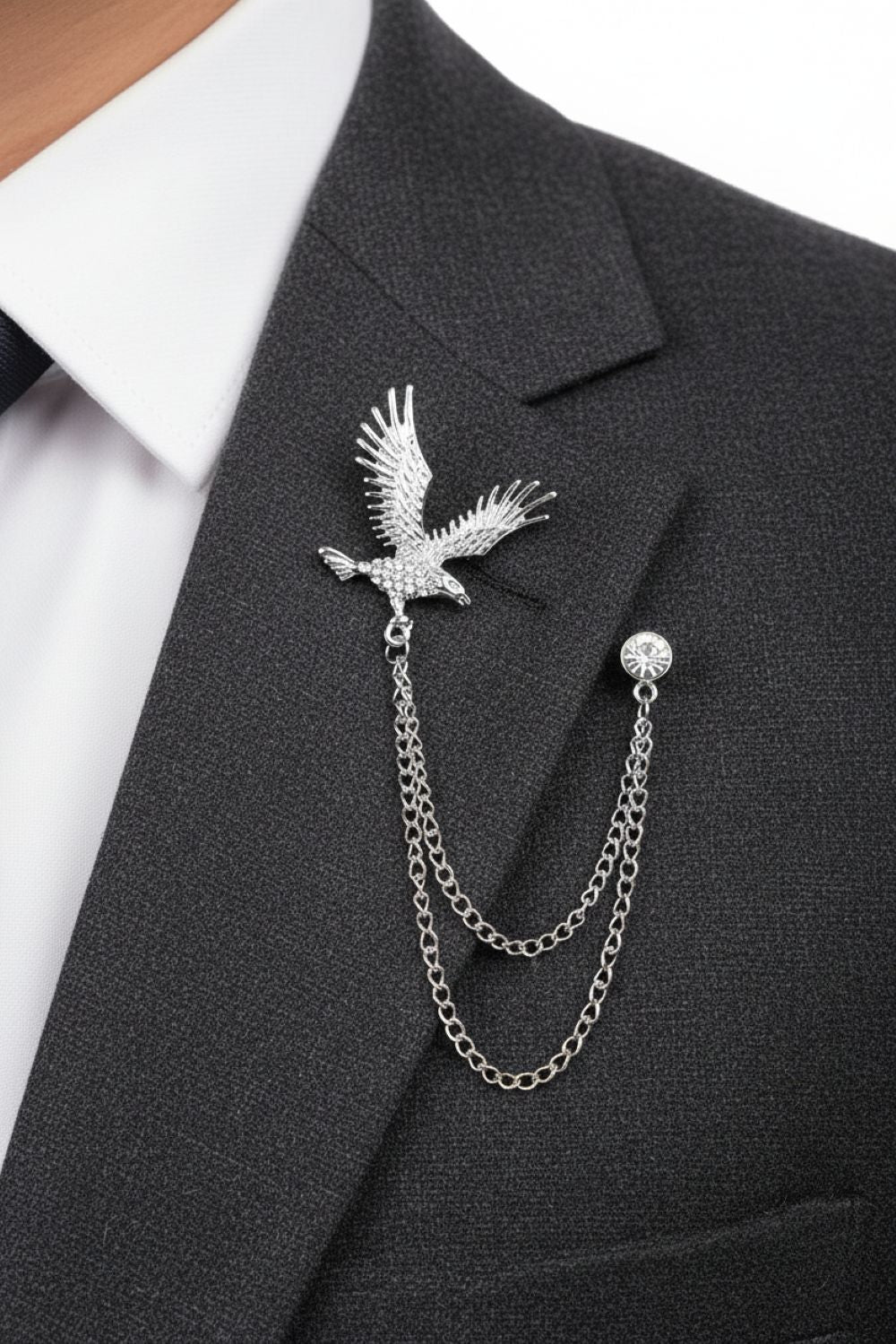 Silver eagle brooch with chain on a black suit jacket