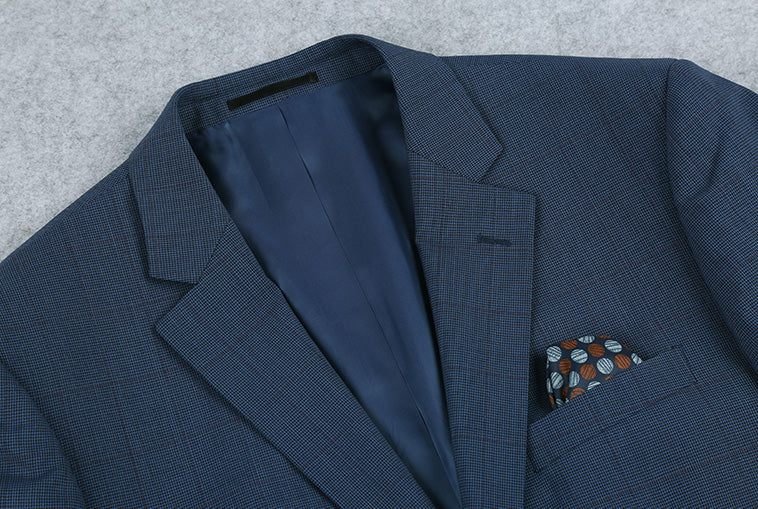 Close-up of blue 100% wool mini check blazer collar, buttons, and pocket.