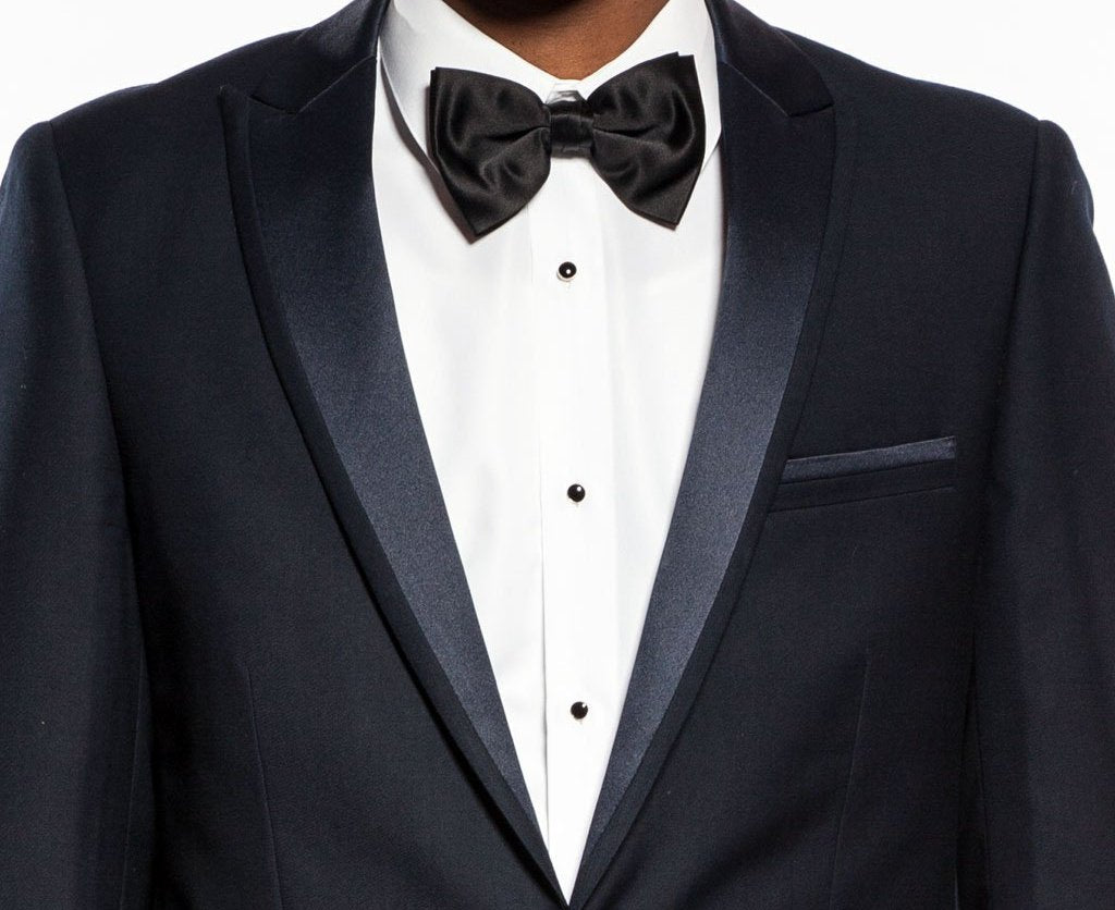 A solid Tazio Slim Fit 2 Piece Navy Tuxedo jacket, showing collar, buttons, pockets, with a tie and bow tie.