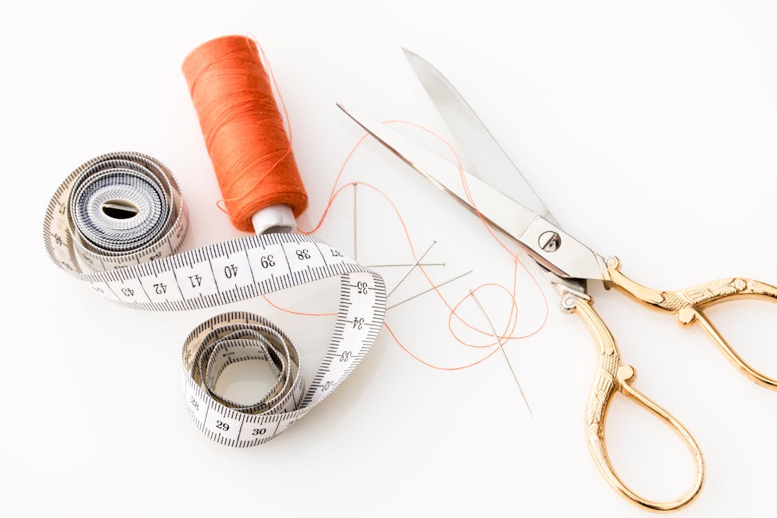 a set of sewing tools on a white surface