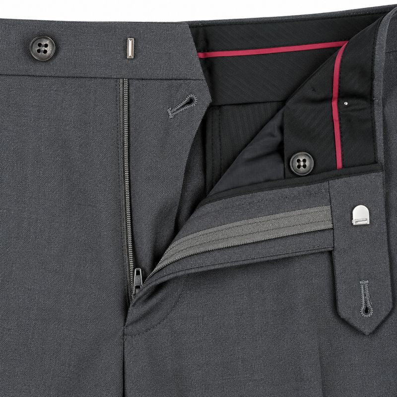 Close-up of dark gray tailored trousers showing the waistband, front zip closure, button details, and interior lining with a contrasting pink edge.