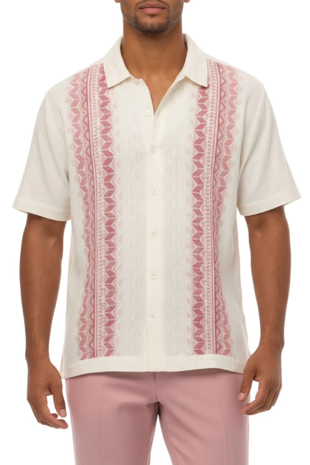 Man wearing a white shirt with red patterns and pink pants on a white background