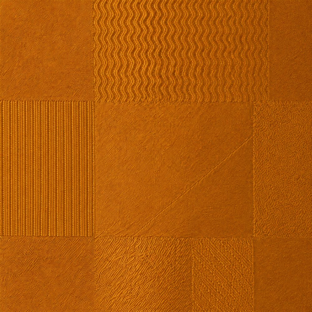 A close-up of a textured Gold fabric or wallpaper swatch with a patchwork grid pattern showing different woven and ribbed textures.