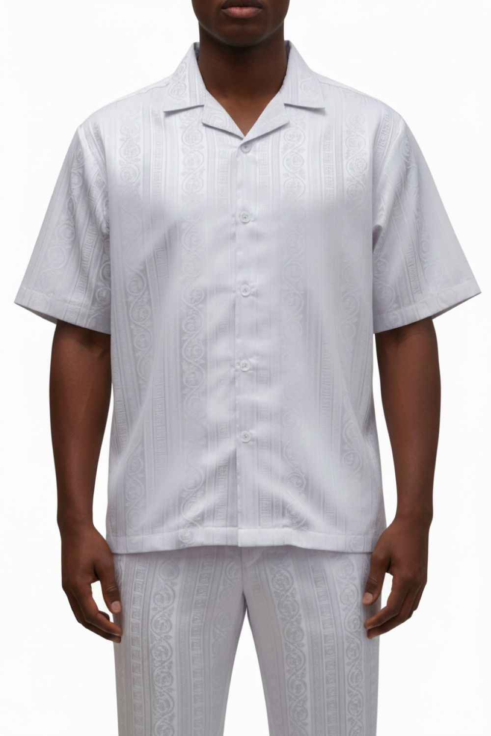 Man wearing a light gray patterned shirt and pants on a white background