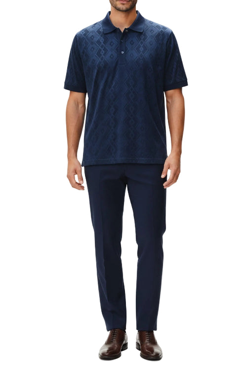 Man wearing a navy patterned polo shirt and pants on a white background