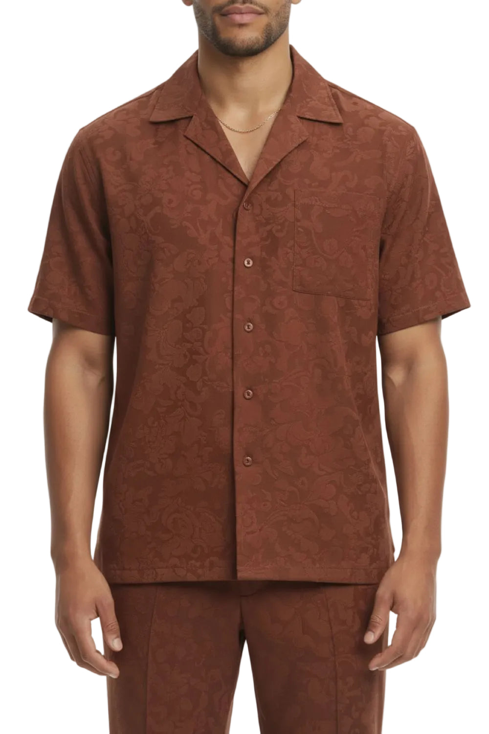Man wearing a brown patterned shirt and pants on a white background