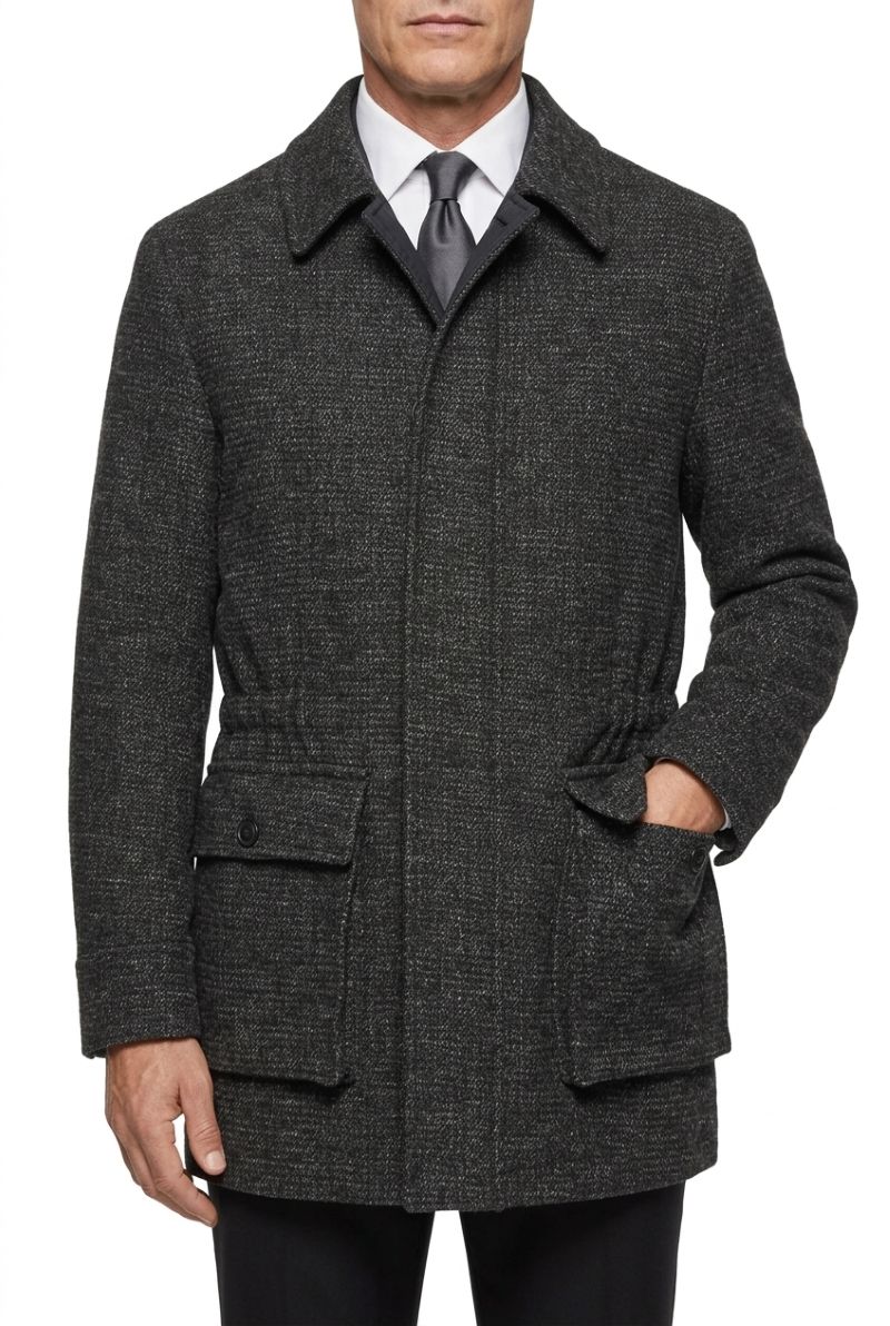 A man wearing a dark charcoal gray textured wool-blend coat over a white collared shirt and a dark gray tie, shown from the waist up against a plain white background.