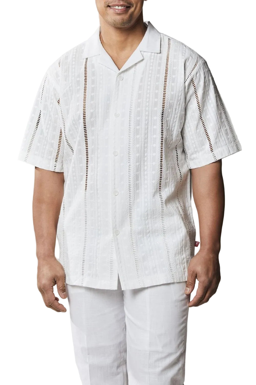 Man wearing a white patterned shirt and pants on a white background