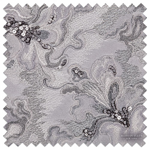 A square fabric swatch with zigzag-cut edges, featuring an abstract swirling pattern in shades of gray, black, and white, with sequined floral accents.