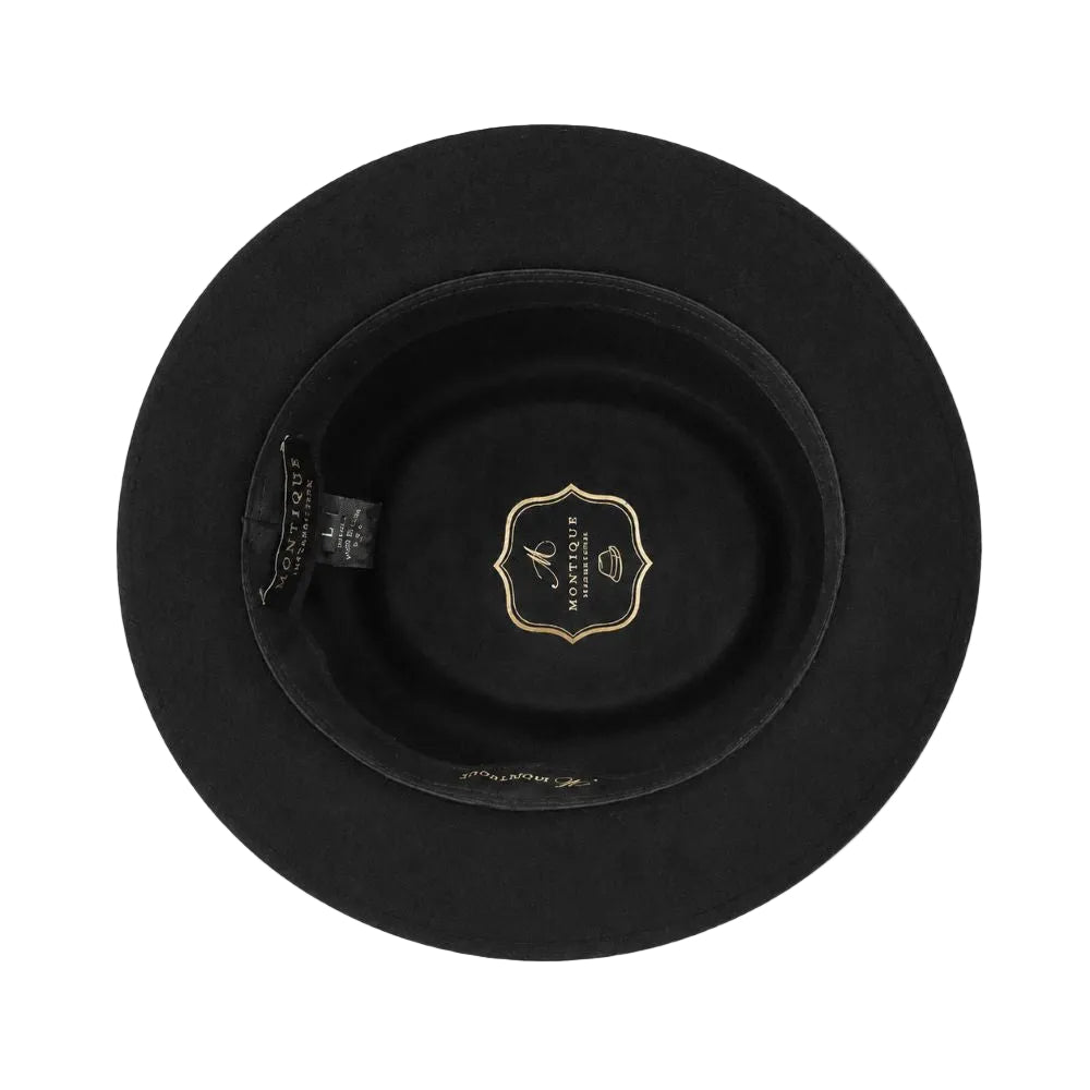 Top-down view of a black felt wide-brim hat with a gold crest label in the center and a black interior tag on the left side, set against a plain white background.