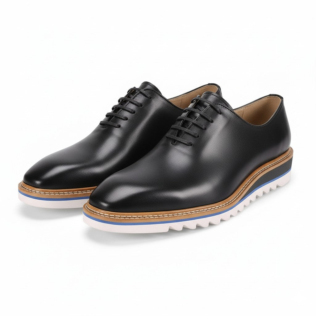 Pair of Charcoal leather shoes with white soles on a white background