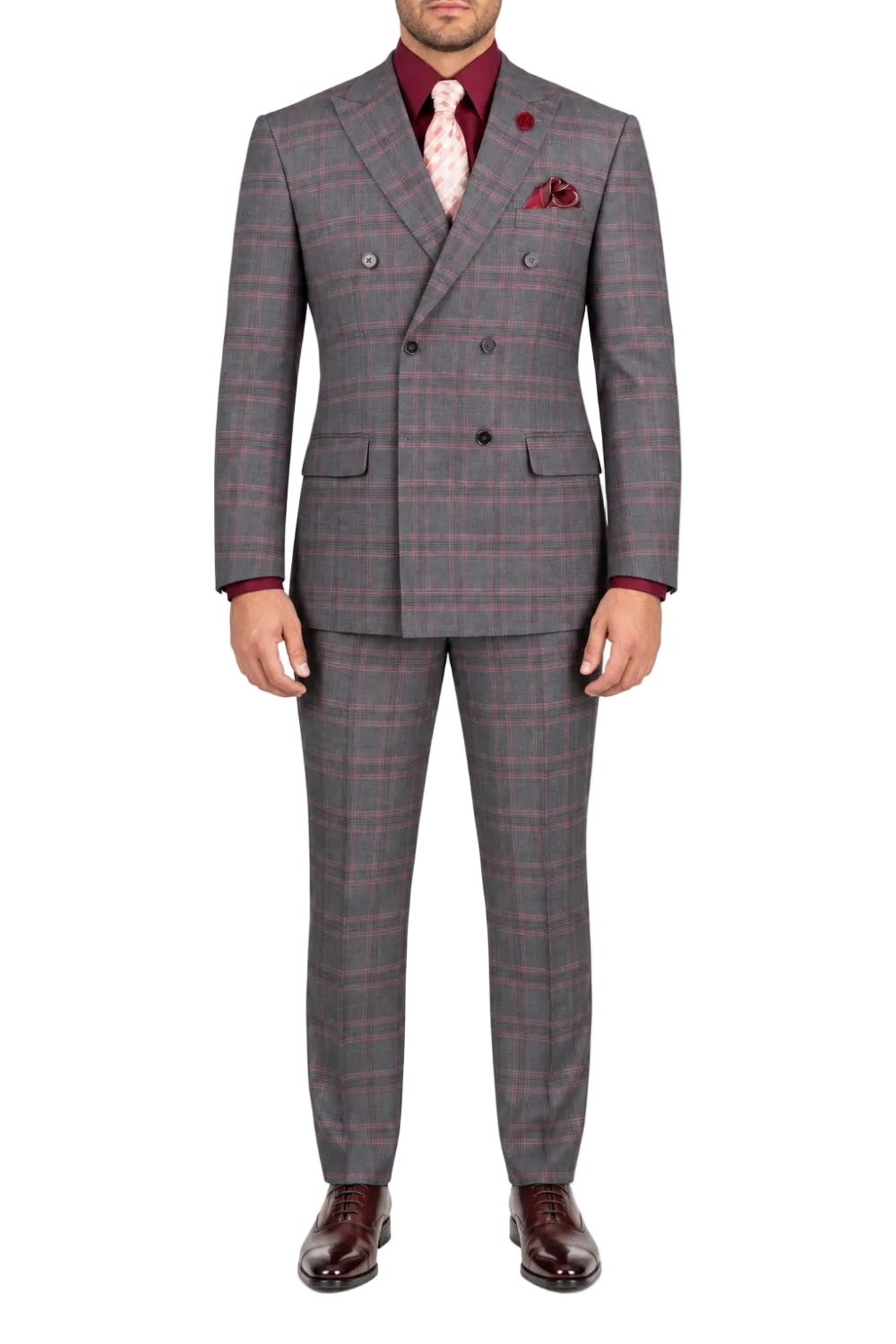 A man wearing a gray double-breasted suit with a red and pink windowpane plaid pattern, styled with a burgundy shirt, pink tie, and dark brown dress shoes, photographed against a solid white background.