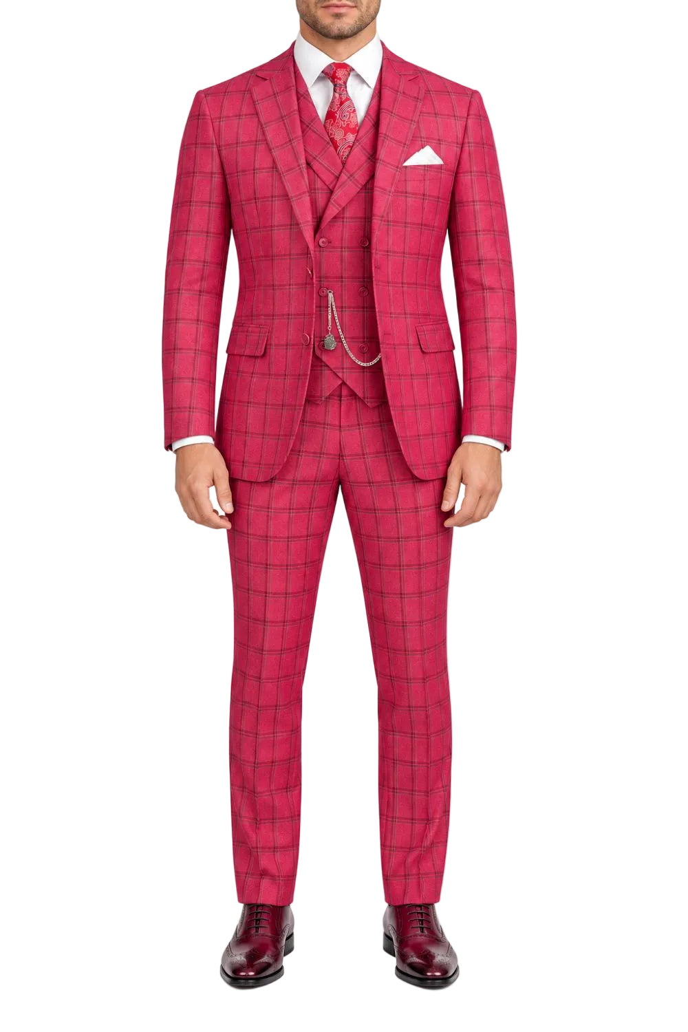 A man wearing a bright pink three-piece suit with a subtle windowpane plaid pattern, paired with a white dress shirt, a red patterned tie, and dark burgundy dress shoes, photographed against a solid white background.