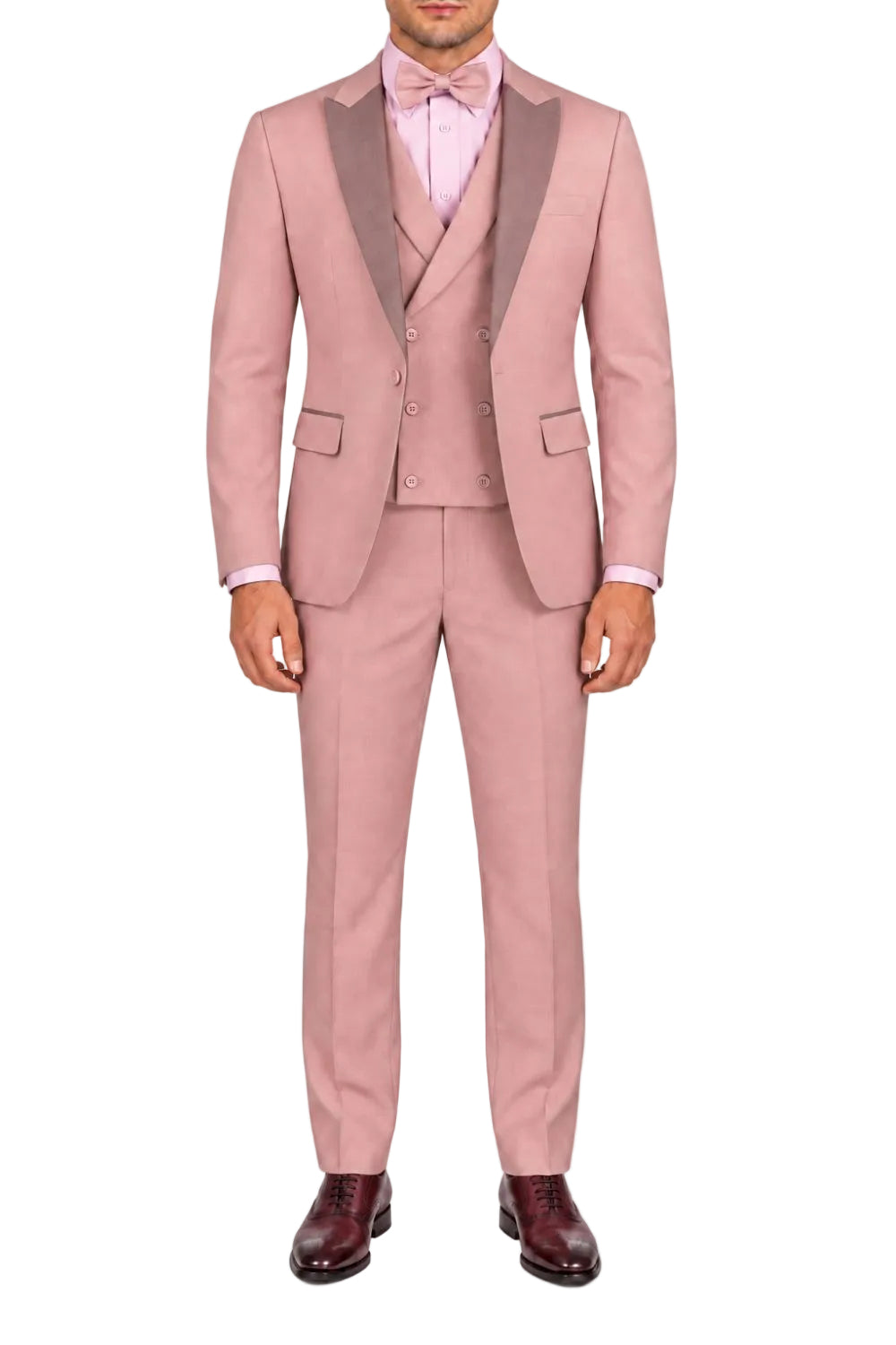 A man wearing a pink three-piece suit with dark gray shawl lapels, a matching pink vest and trousers, a light pink dress shirt, and a pink bow tie, paired with dark brown dress shoes, against a plain white background.