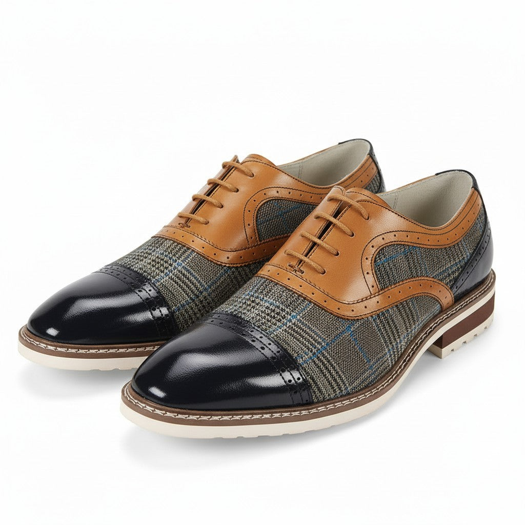Pair of men's dress shoes with plaid pattern and navy toes on a white background