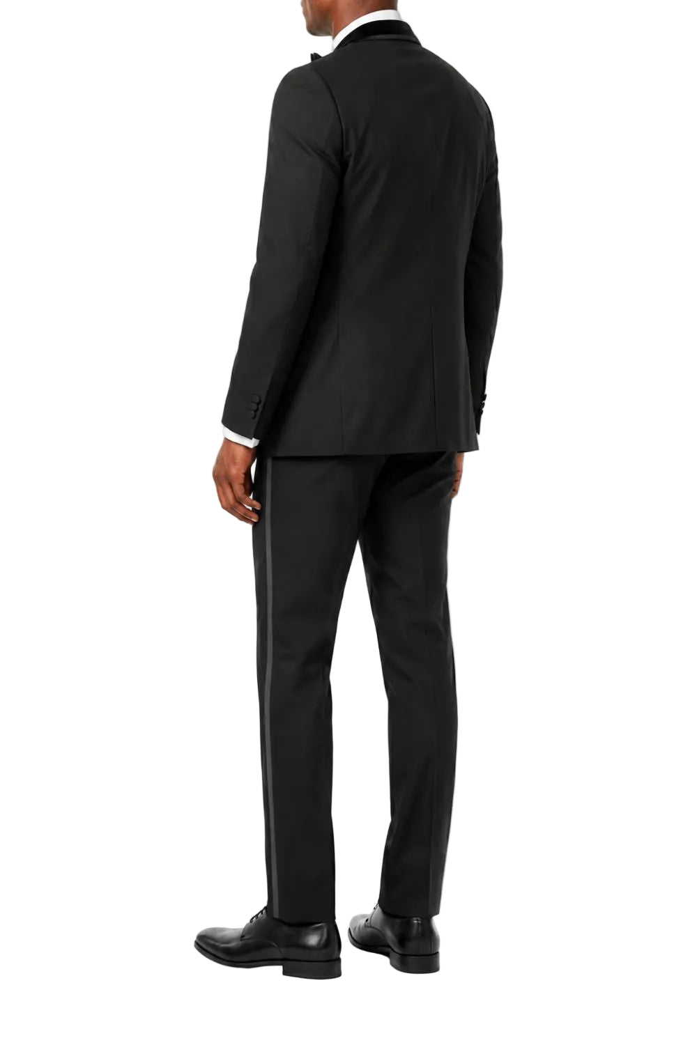 A man wearing a black tuxedo jacket and matching trousers, viewed from the back against a plain white background.