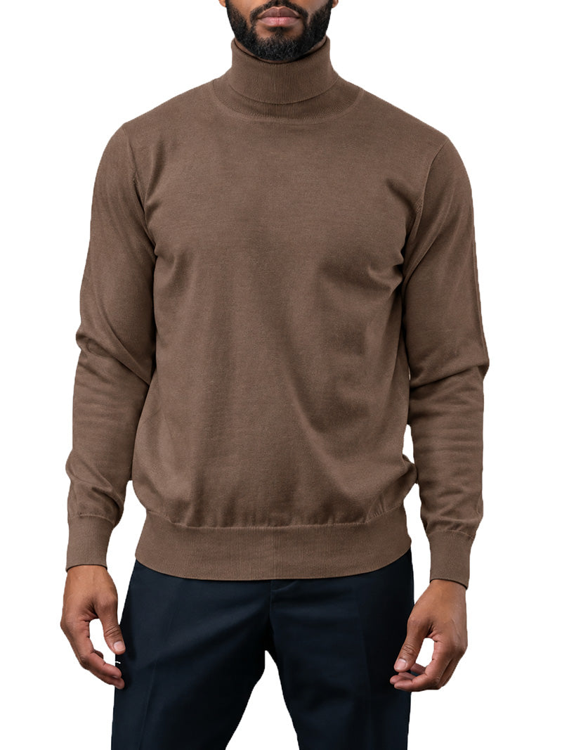 A man wearing a brown ribbed turtleneck sweater and dark navy pants, shown from the chin down against a plain white background.