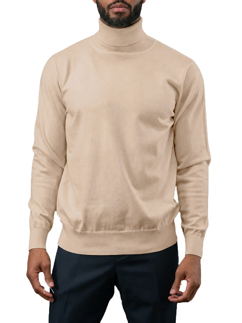 A man wearing a beige long-sleeve turtleneck sweater and dark trousers, shown from the chin down against a plain white background.