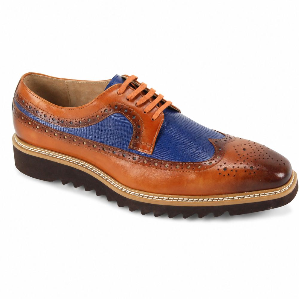 A men's wingtip oxford shoe featuring a tan leather upper with a vibrant blue fabric panel on the vamp, brown brogue detailing, and a dark brown lug sole.