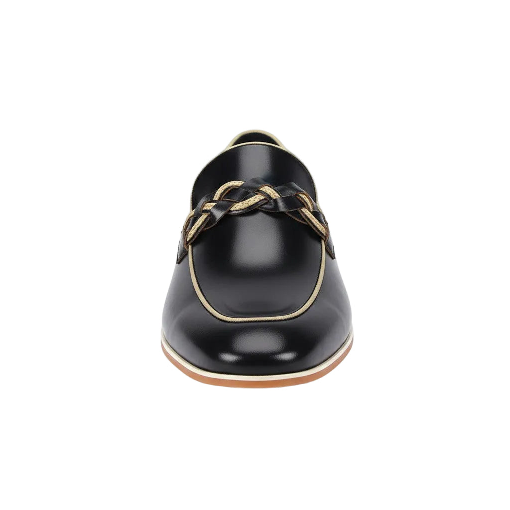 Black leather shoe with gold accents on a white background